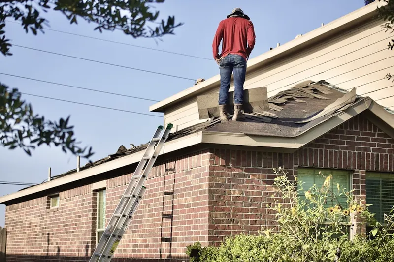 Professional roofer working on a residential roof in Osterville